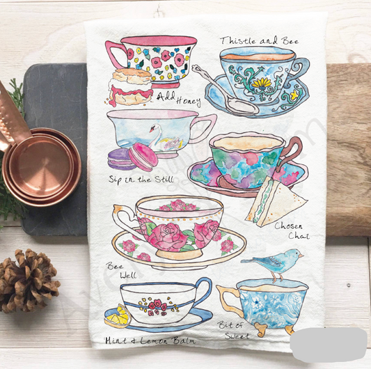 Teacups with floral designs and text on a white background, surrounded by copper mugs and a pine cone.