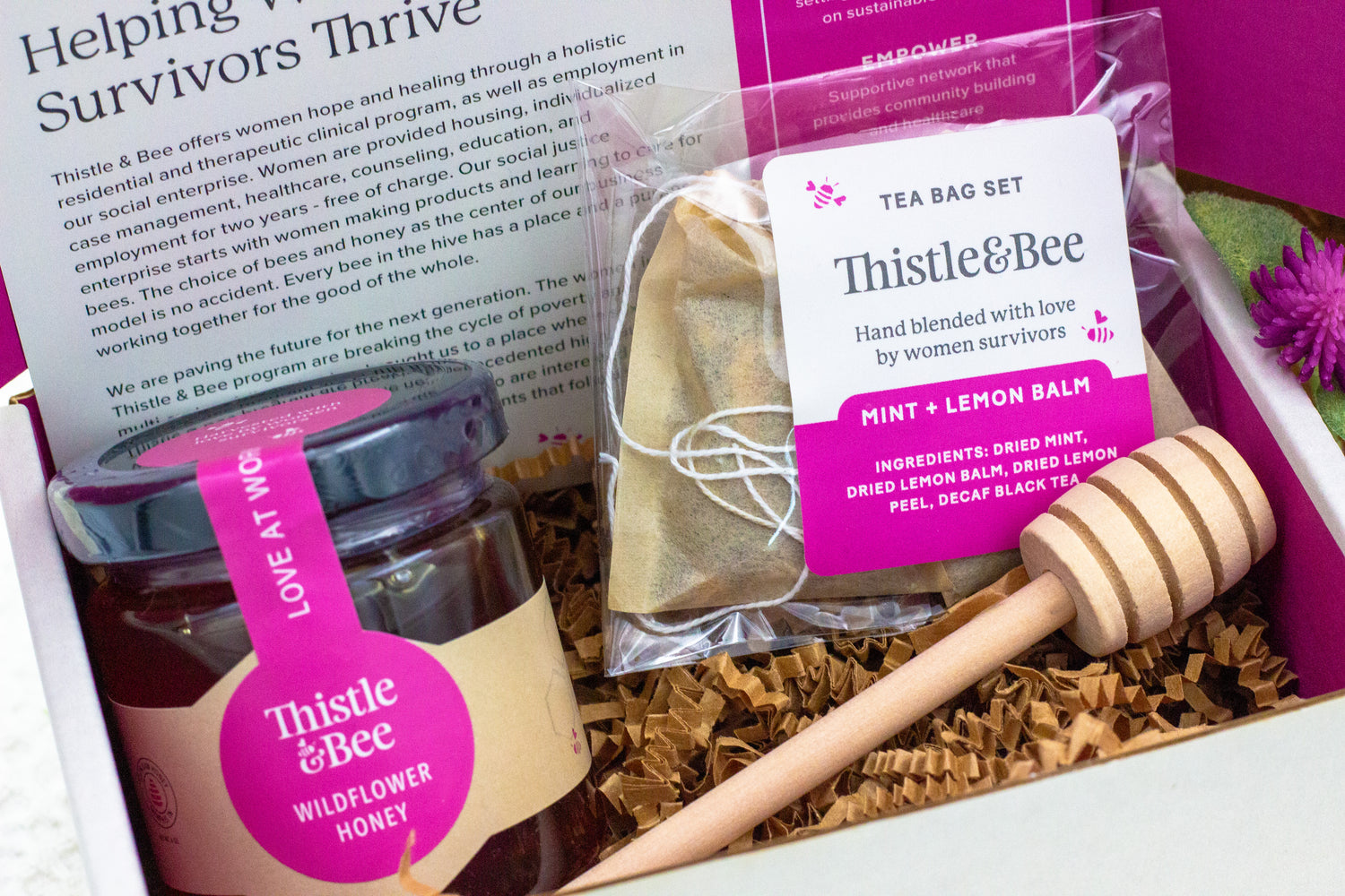 Gift set with Thistle & Bee products including honey, tea bags, and a wooden dipper.